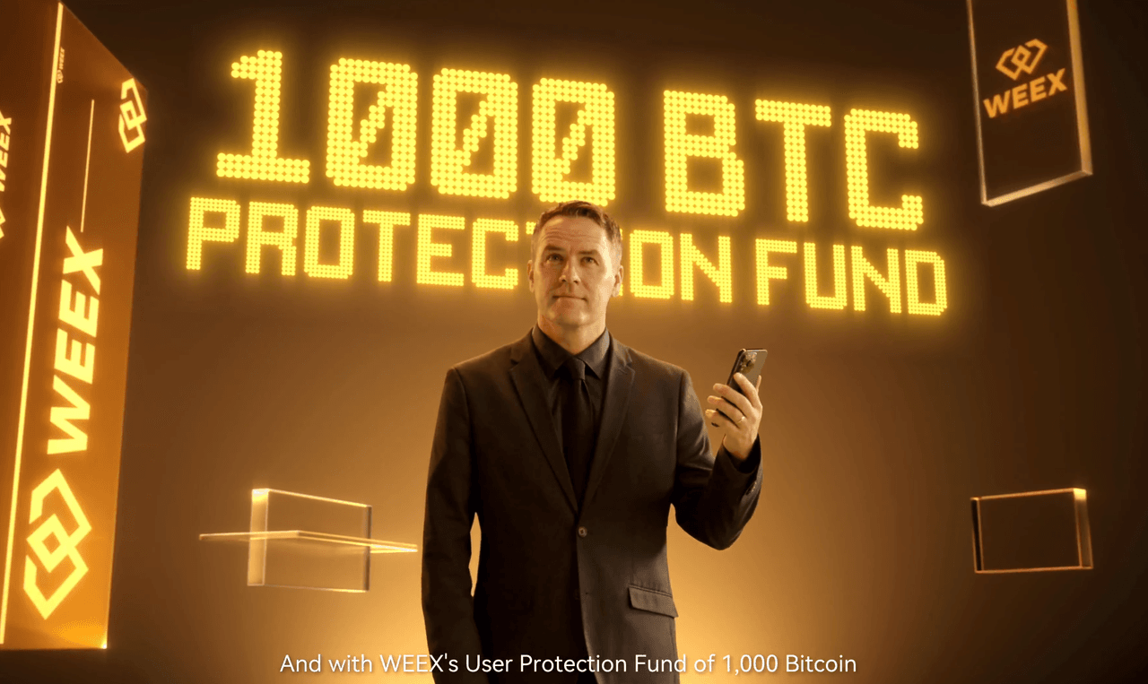 Michael Owen steht in einem goldenen Raum mit einem Smartphone in der Hand. Hinter ihm leuchtet der Schriftzug „1000 BTC Protection Fund“ in großen gelben Buchstaben, umgeben von WEEX-Logos.
